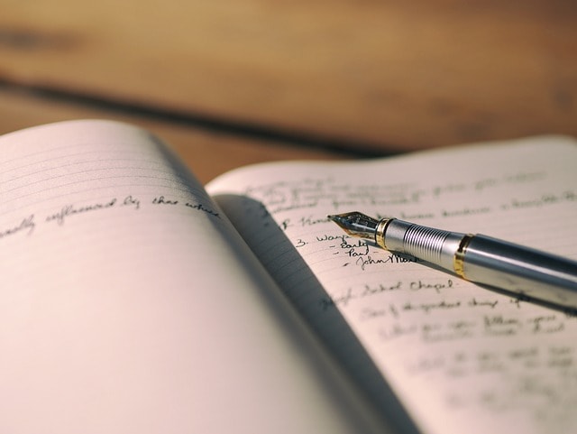 A fountain pen on top of a notebook.