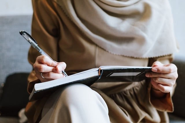 A woman writing notes in a notebook.