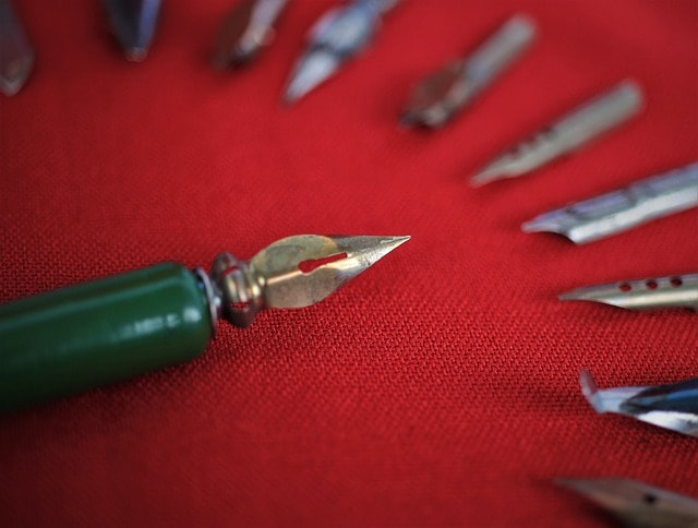 A fountain pen and fountain pen tips on a red surface.