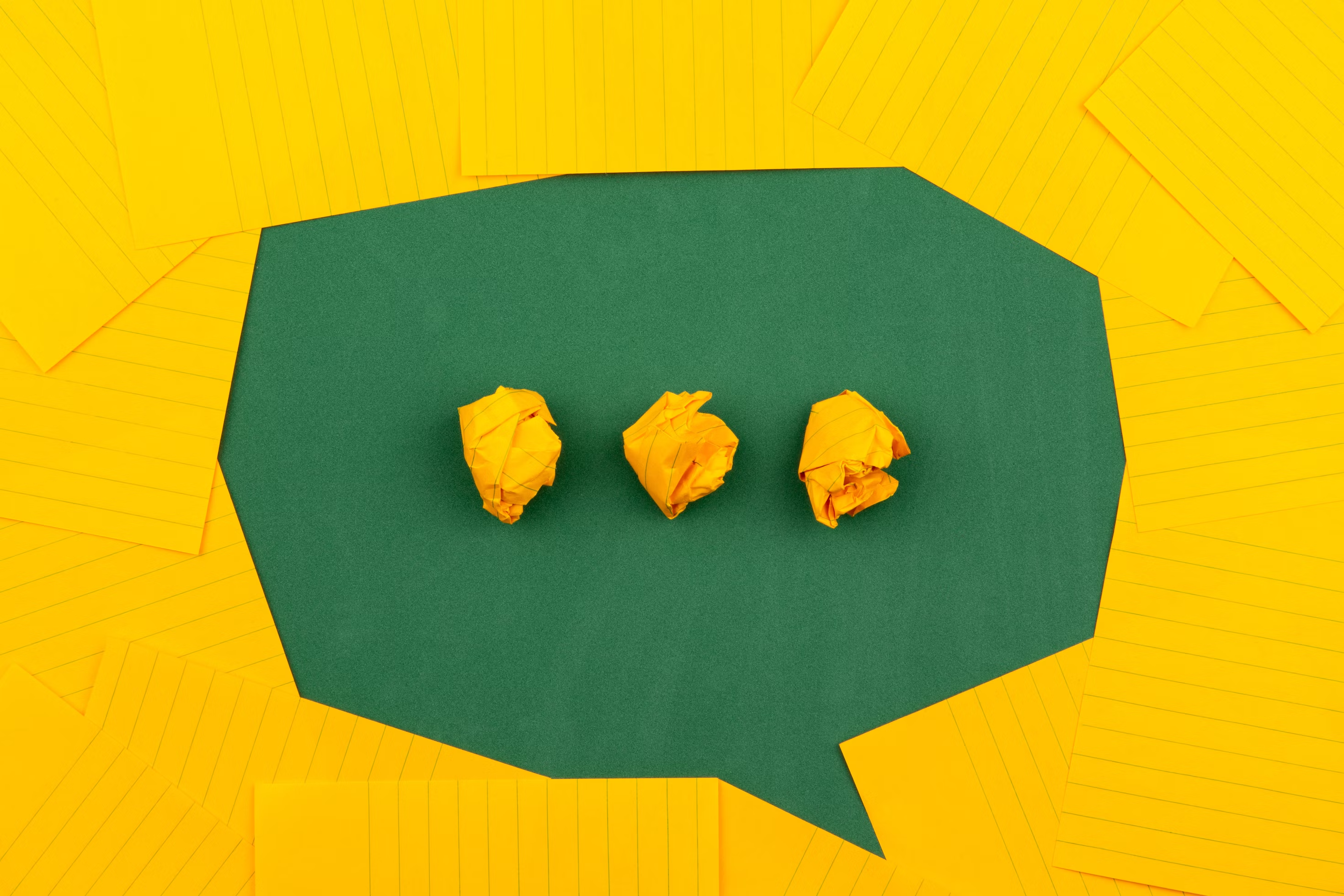 Crumpled yellow paper and green card arranged to look like a Messenger icon.