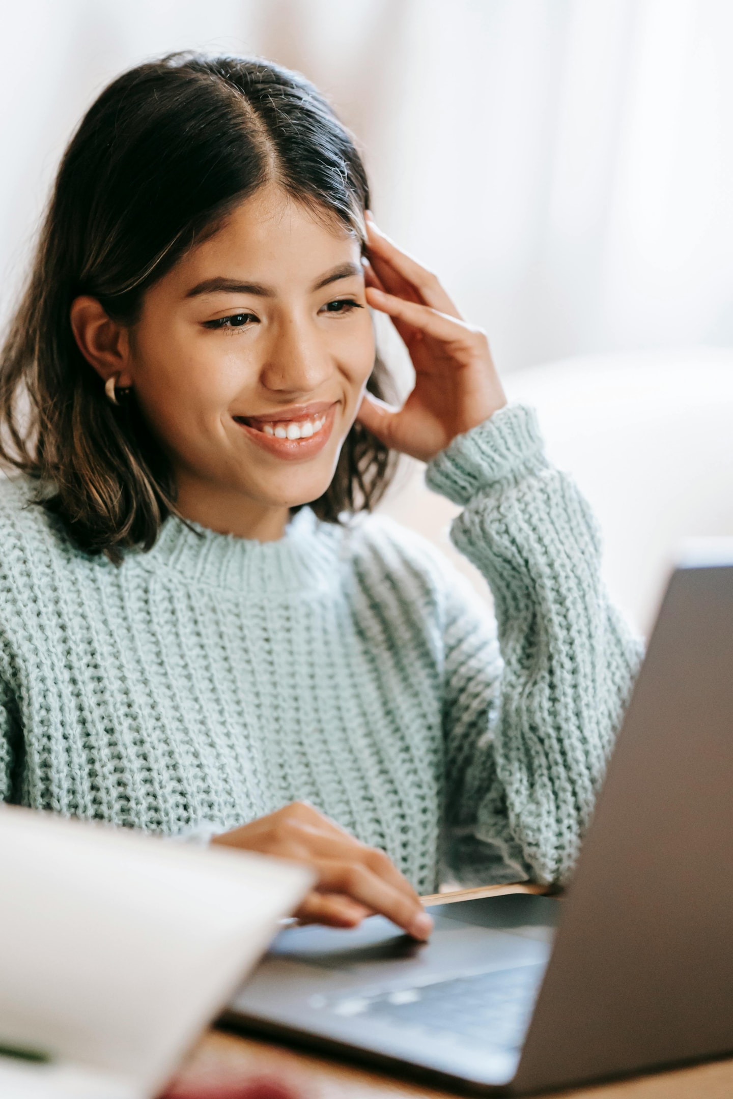 A woman working on her laptop and smiling.