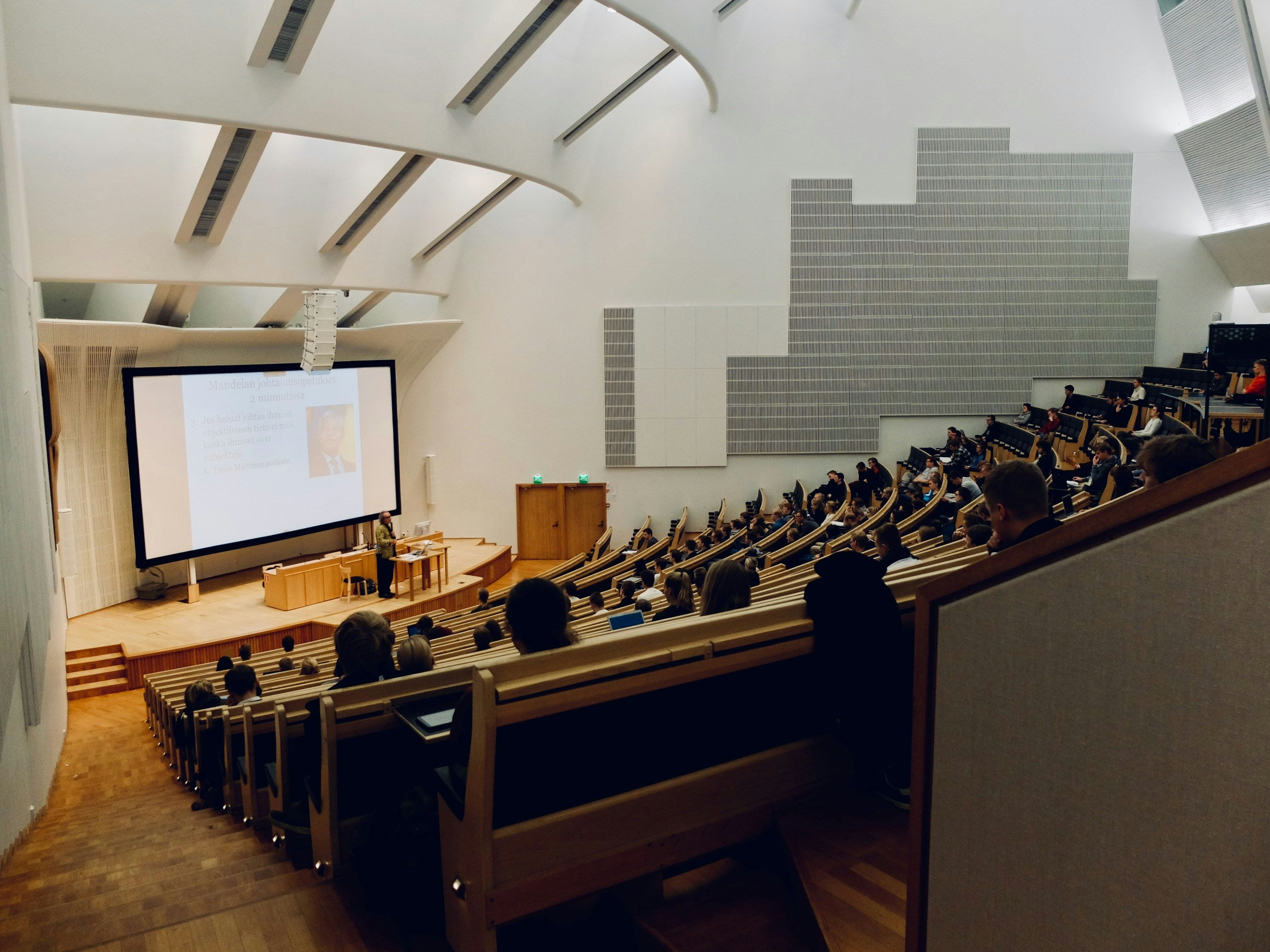 A college lecture hall with students observing a professor's presentation.