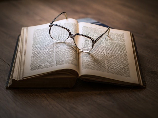 A pair of reading glasses on top of a book.