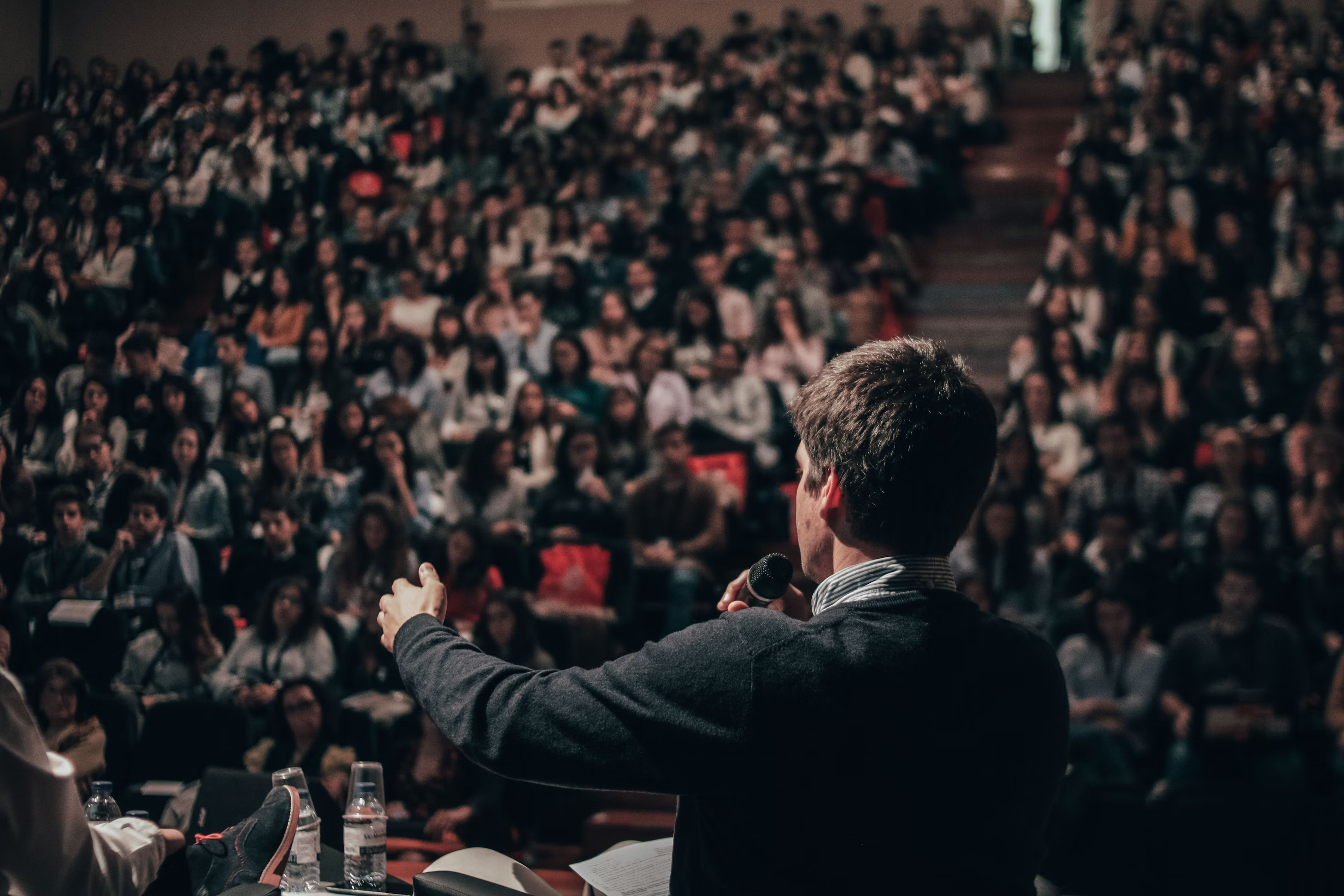 A man giving a speech in front of a large crowd.