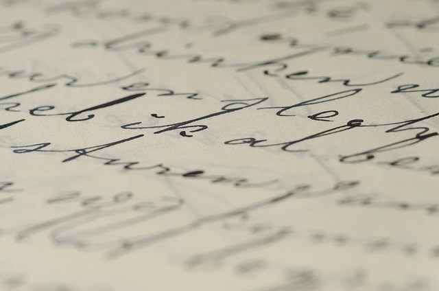 Letters on a page written with a calligraphy style.