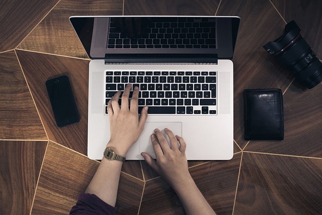 A person typing in a laptop.