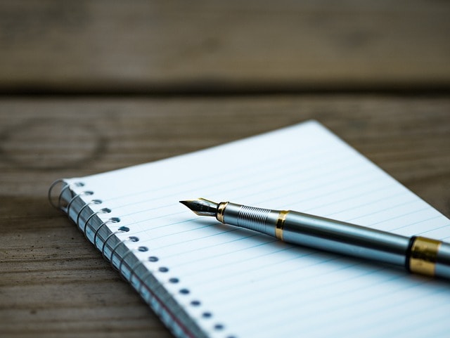 A fountain pen on top of a notebook.