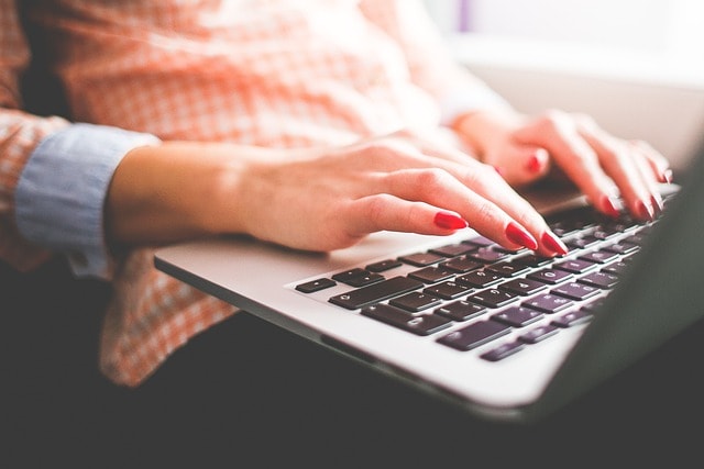 A woman typing on her laptop.