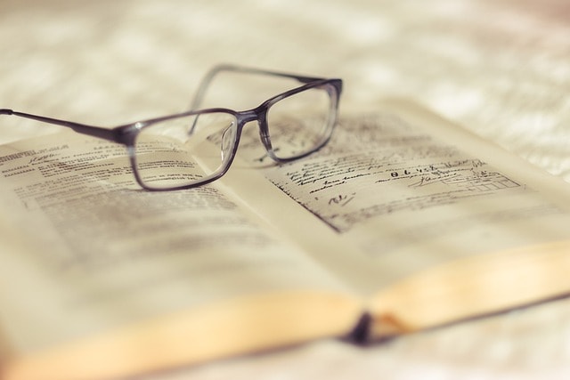 A pair of reading glasses on top of a book.