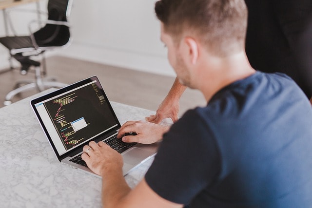 A person coding on their laptop.