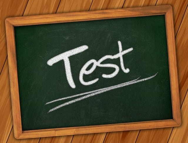 A small blackboard on a wooden surface saying "Test" on it.