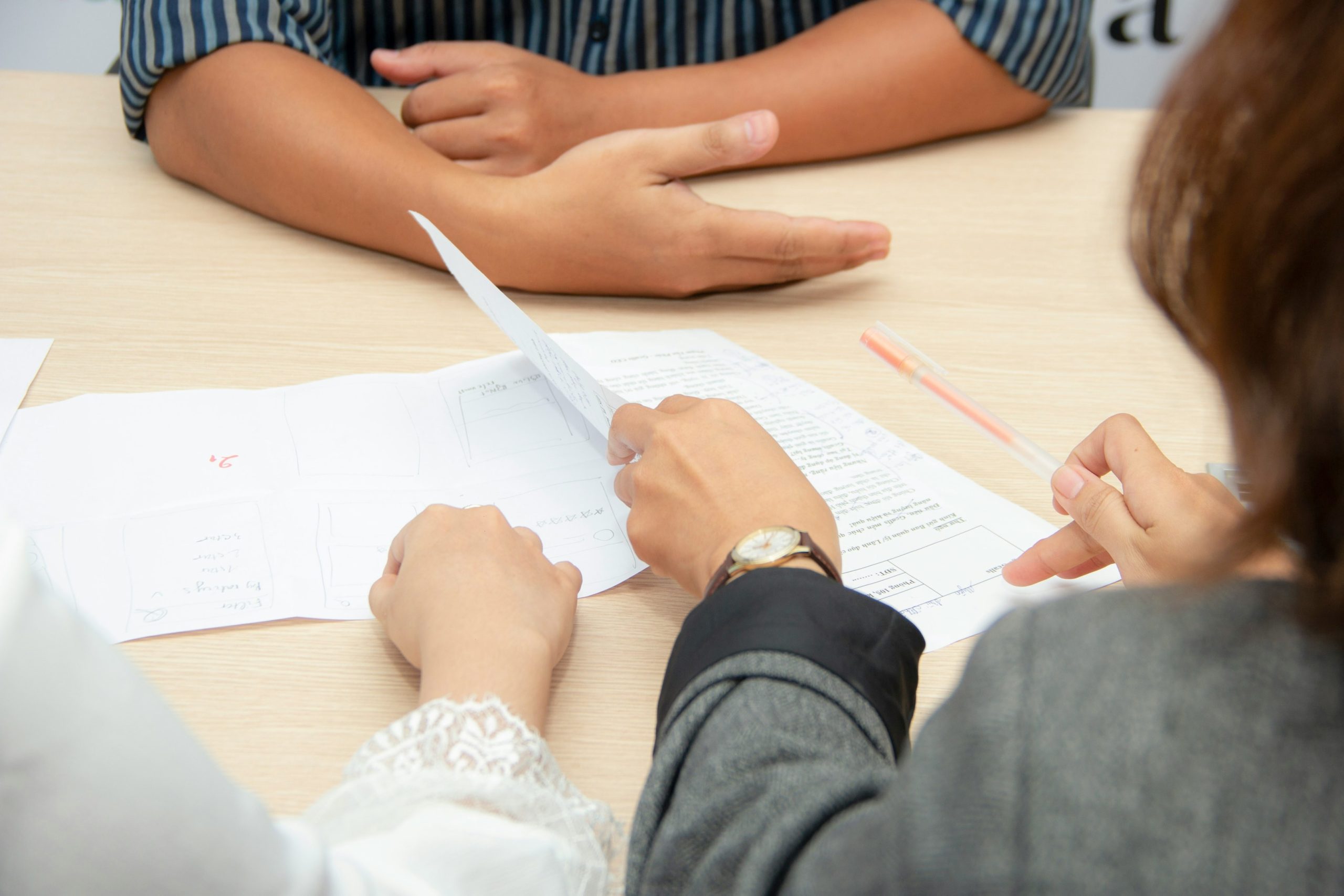 Three people sitting around a table going over some notes.