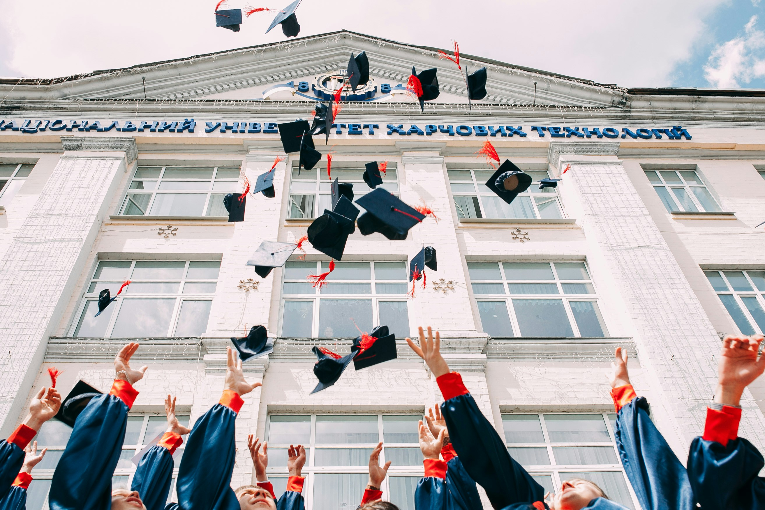 Les diplômés jettent leur casquette en l'air.