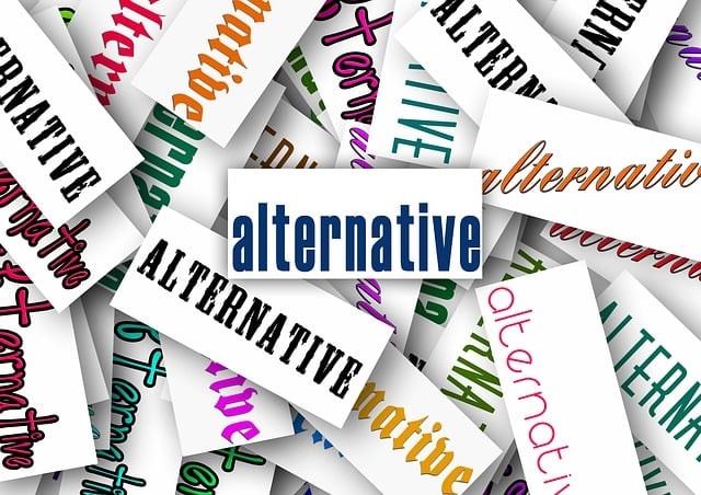 The word "alternative" writing with different fonts and colors on pieces of paper.