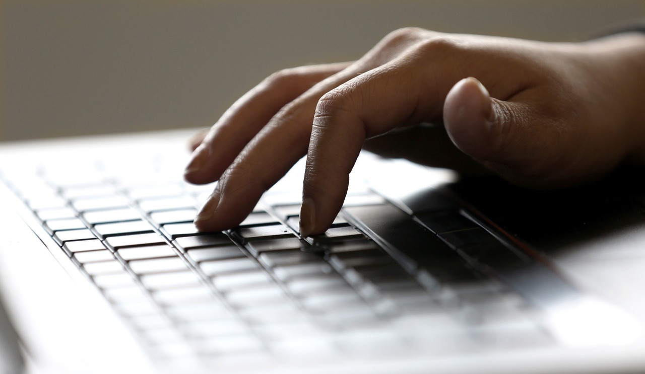 A hand typing on a keyboard