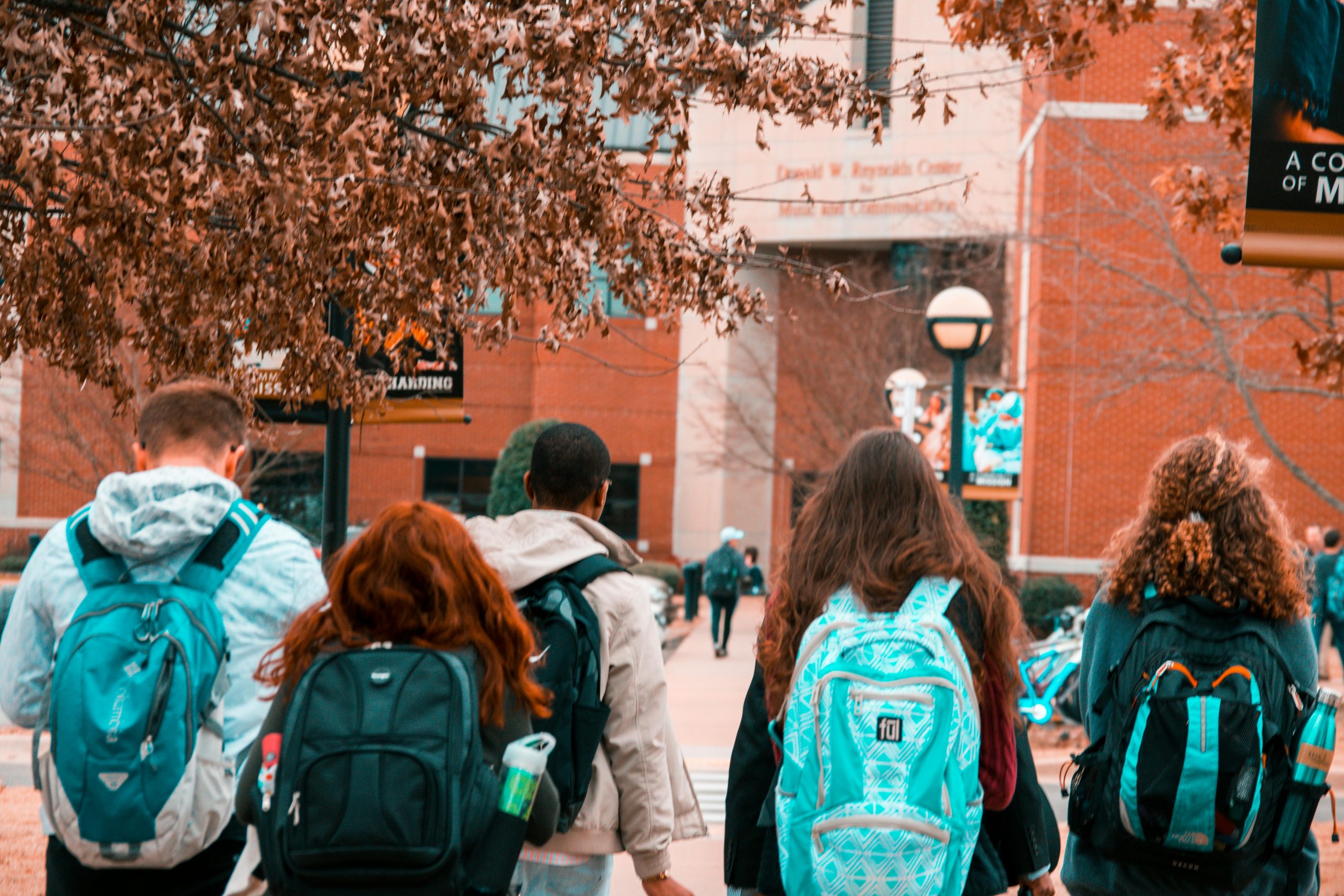 Students going to college with backpacks on their back.