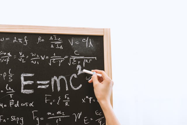 A chalkboard with several math equations written on it. 