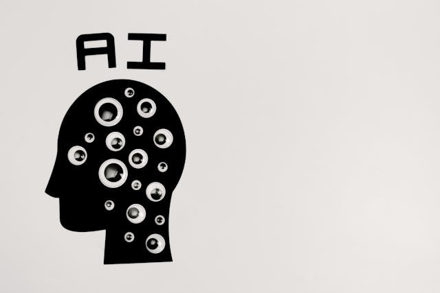 A graphic of a human head with “AI” in text above the head. 