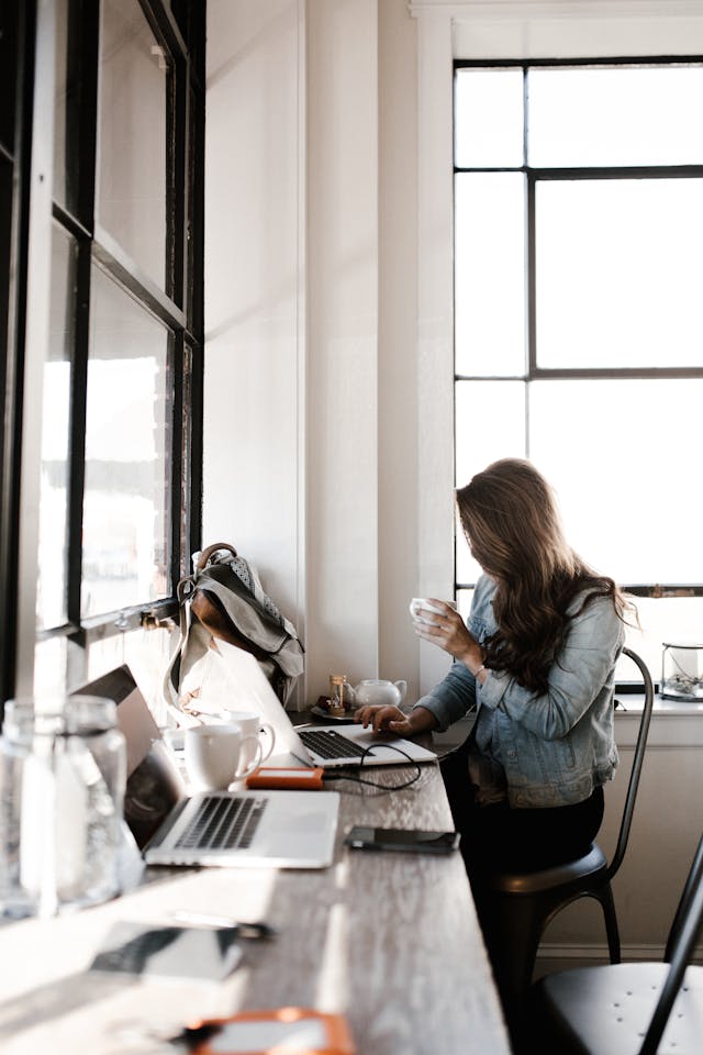 A woman sitting at a desk editing a document on her computer. 