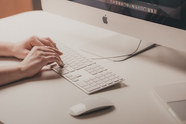 A close-up of a person typing on a keyboard. 