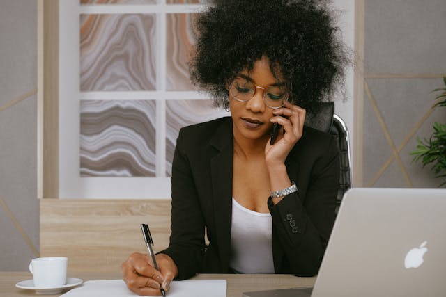 A business woman on her phone and taking notes. 