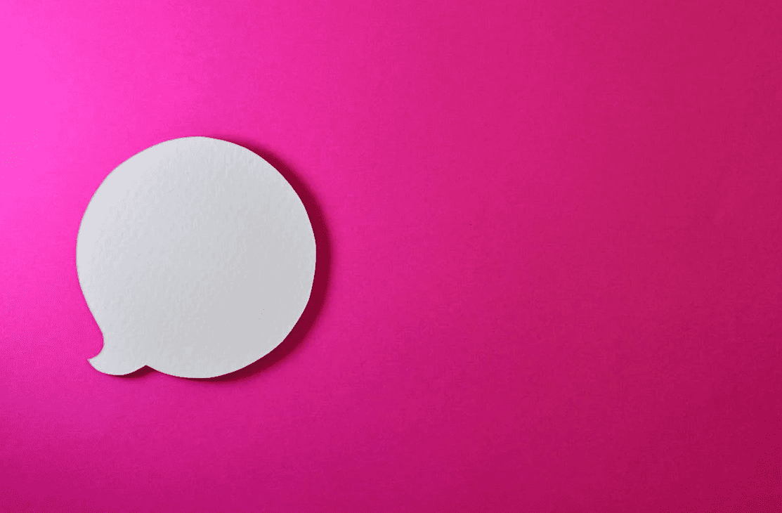 A white chat bubble on a pink background. 