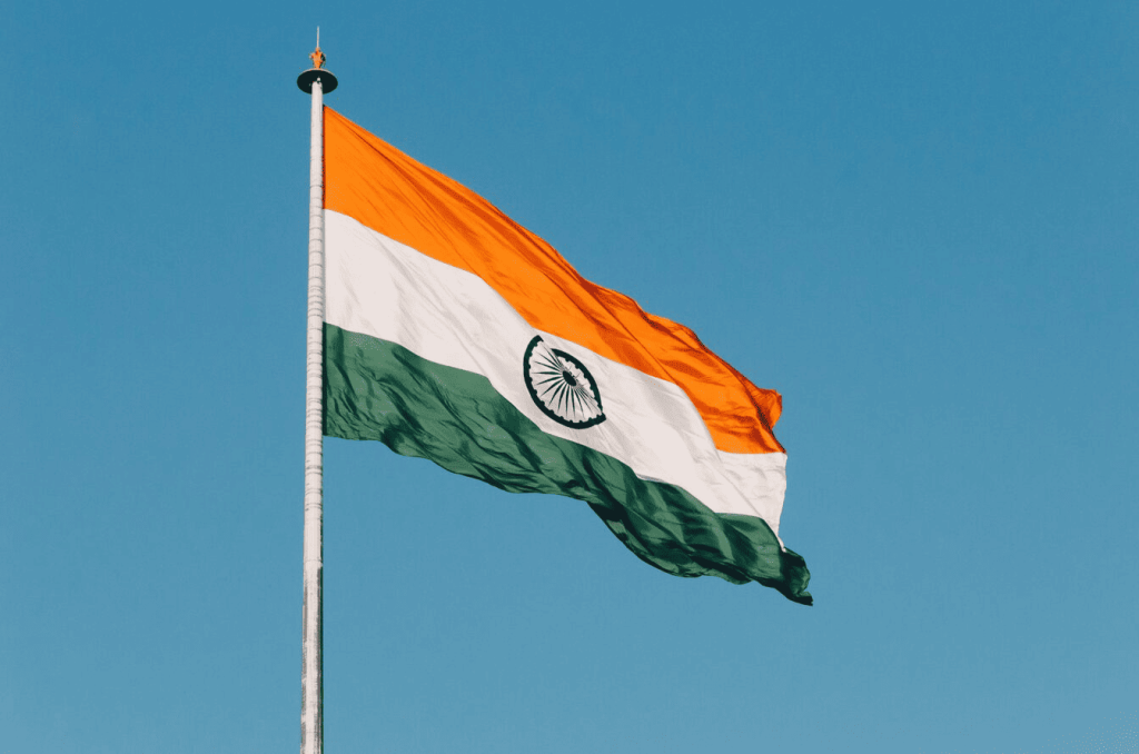 A flag of India with the blue sky in the background. 