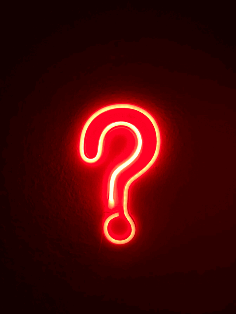 A red neon sign in the shape of a question mark.