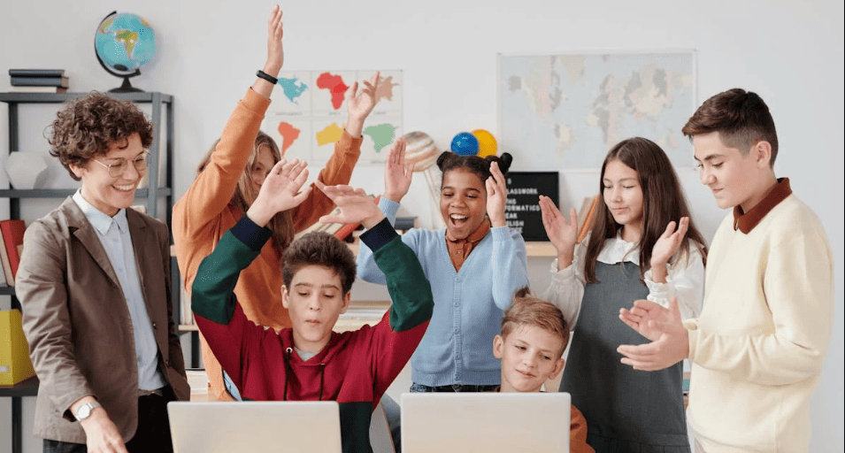 Students celebrating in front of laptops. 