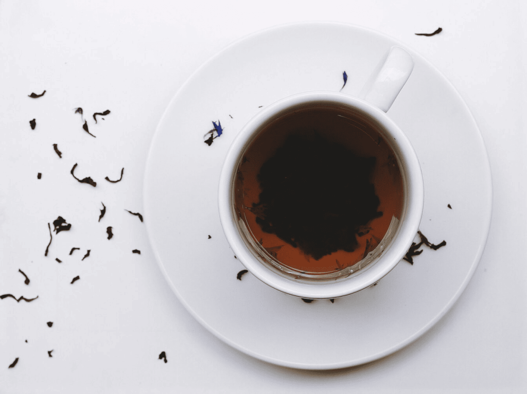 Earl Grey tea in a white cup on a white saucer.