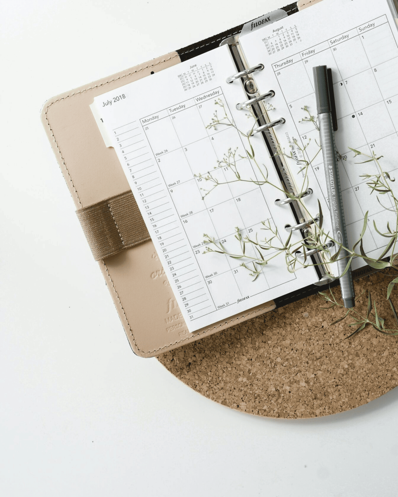 A black pen on top of an open calendar.