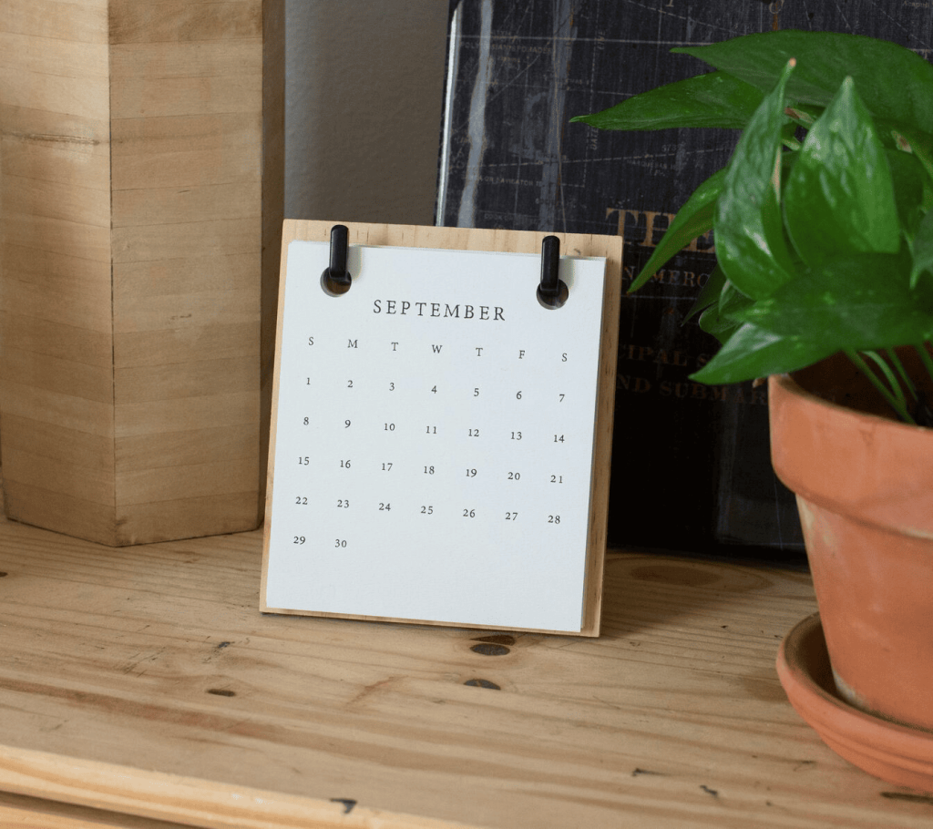 A calendar on a brown wooden table showing the month of September.