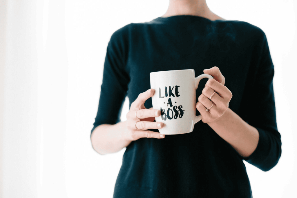 A woman holding a cup that says "Like a boss."