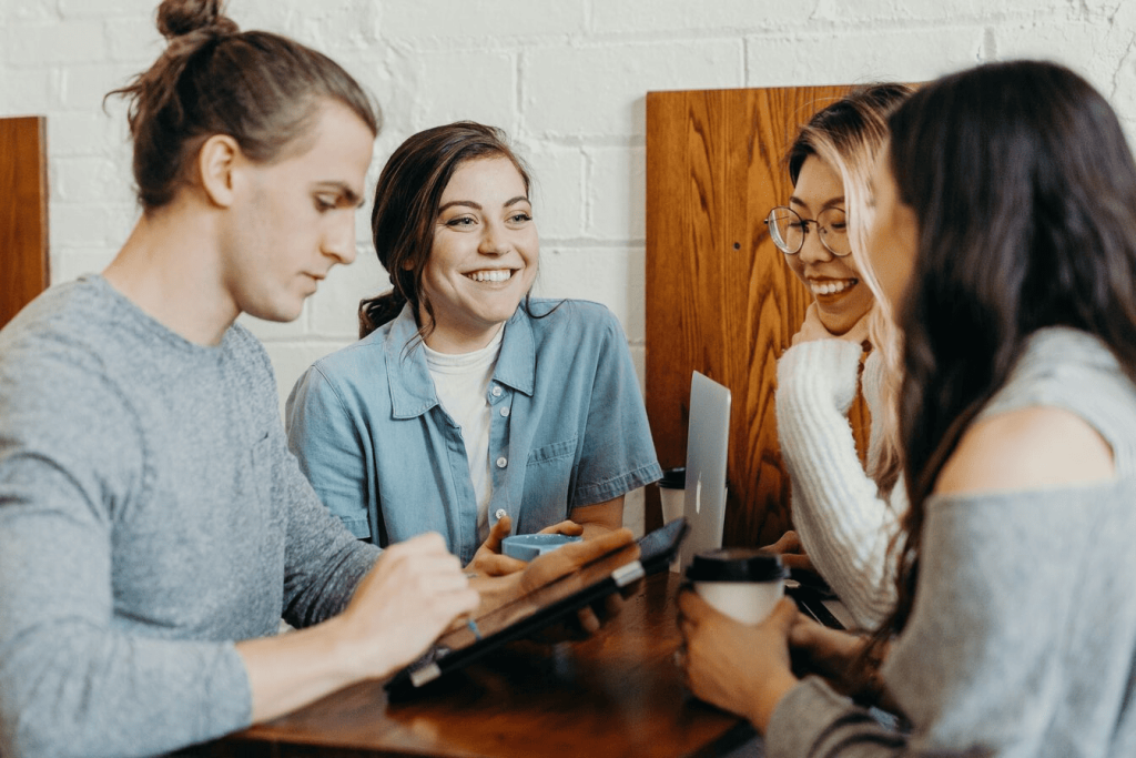 A group of students at a coffee shop laughing.