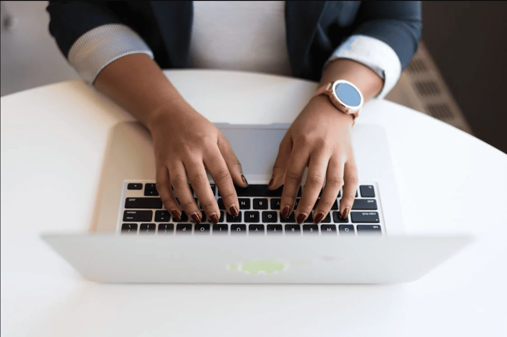 A person typing on a laptop's keyboard.