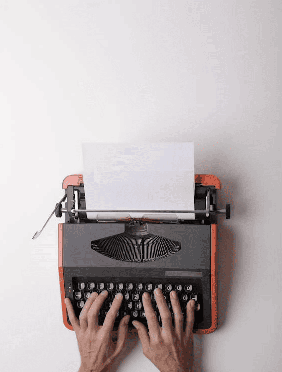 A person typing on a typewriter. 