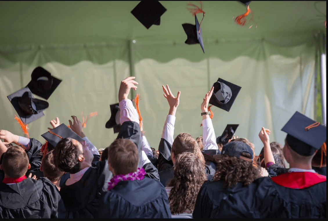 People throwing their graduation caps into the air. 