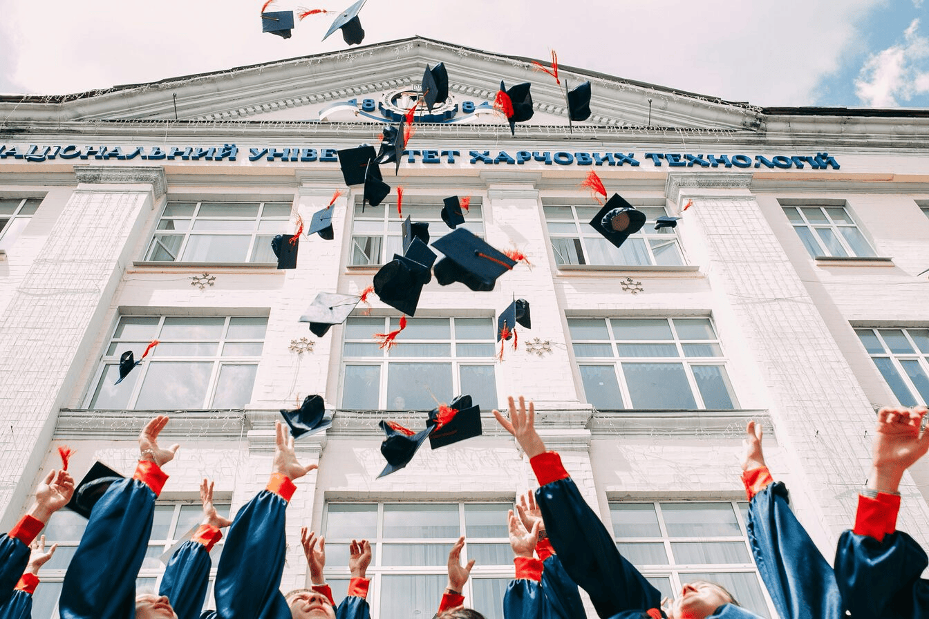 Students throwing their graduation hats into the air. 