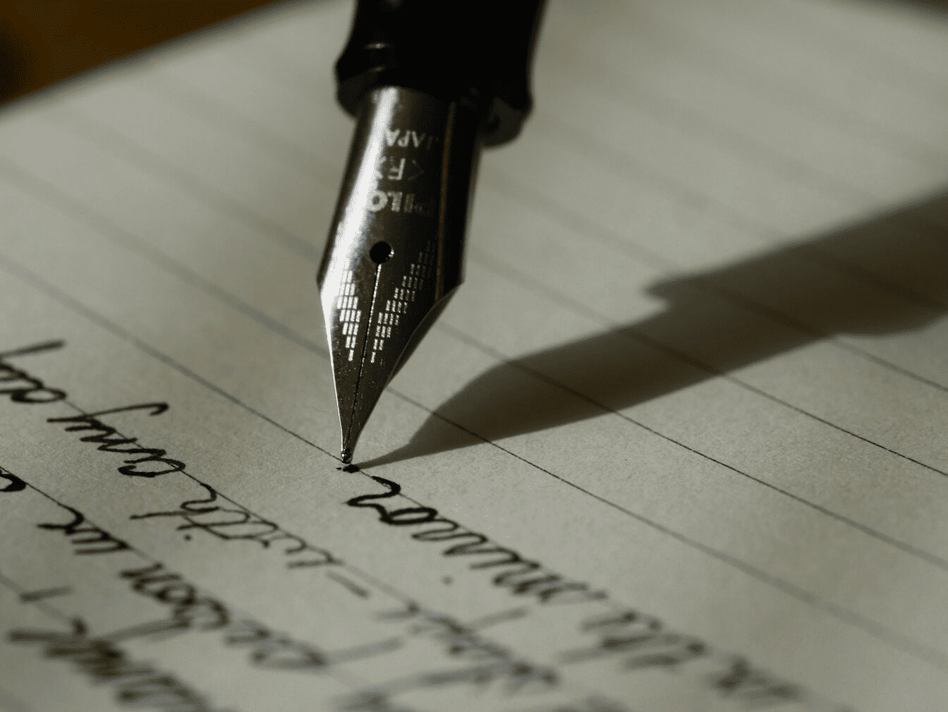 A fountain pen being used for writing.