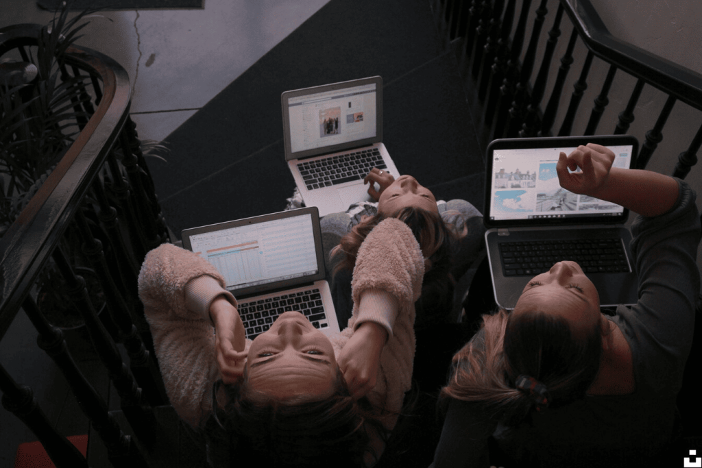 Three people working on their laptops.