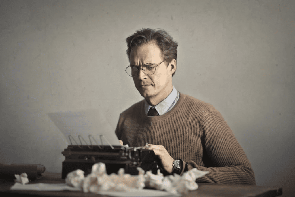 A man using an old-fashioned typewriter. 