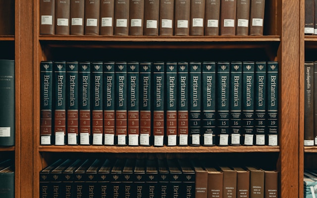 Row of encyclopedias on shelves. 