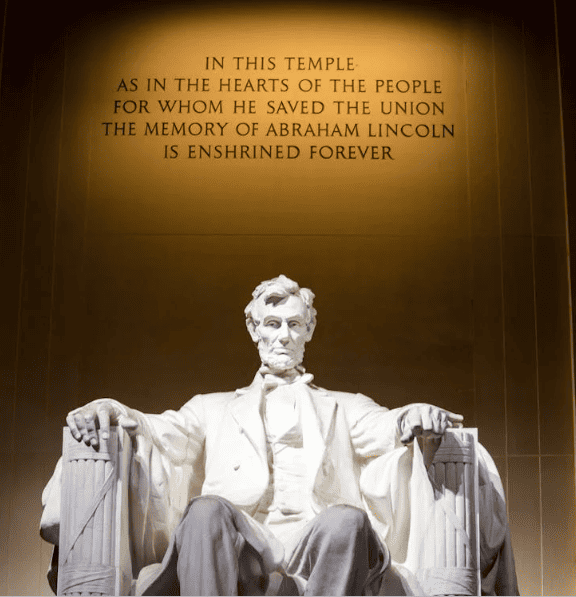 An Abraham Lincoln statue with a quote in the background. 