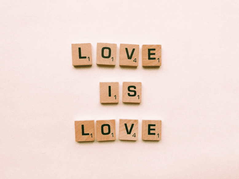 Wooden tiled showing the phrase "love is love."