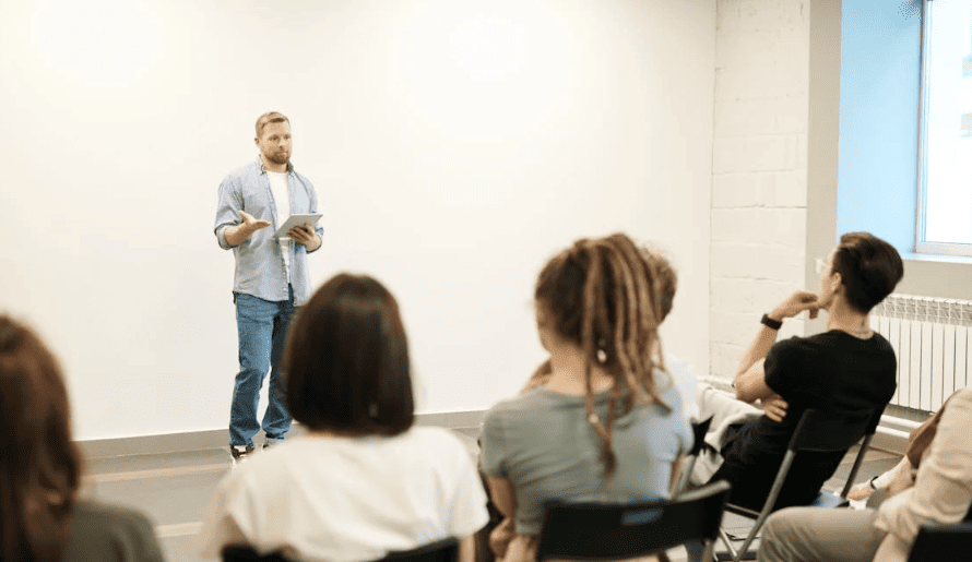 A teacher standing in front of a classroom. 