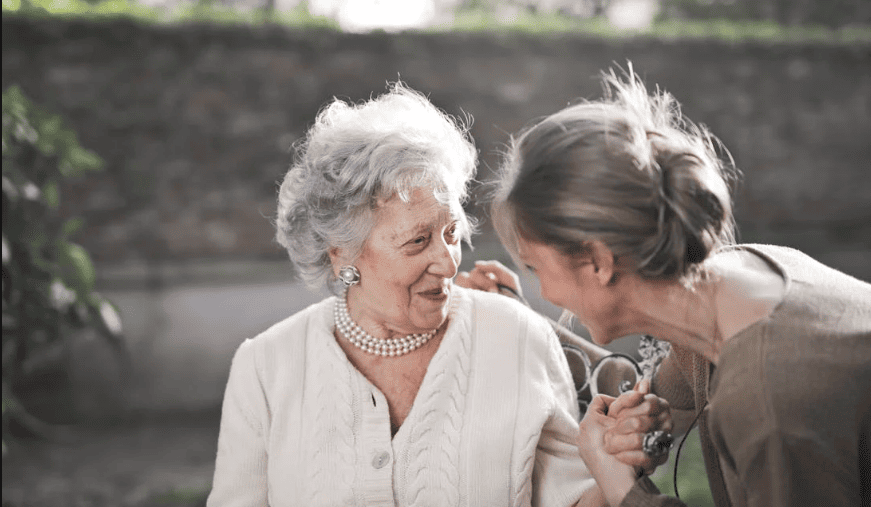 Two adult women beside each other smiling.