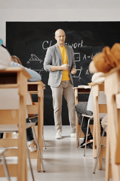 A teacher in a classroom in front of students. 