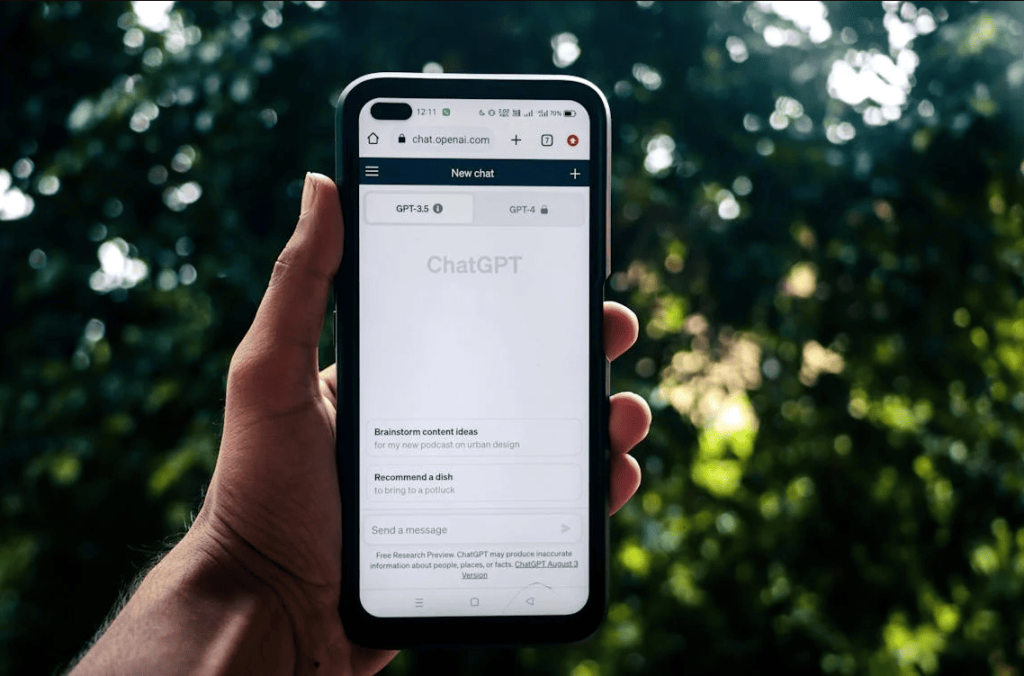A person holding a mobile device and using ChatGPT. 