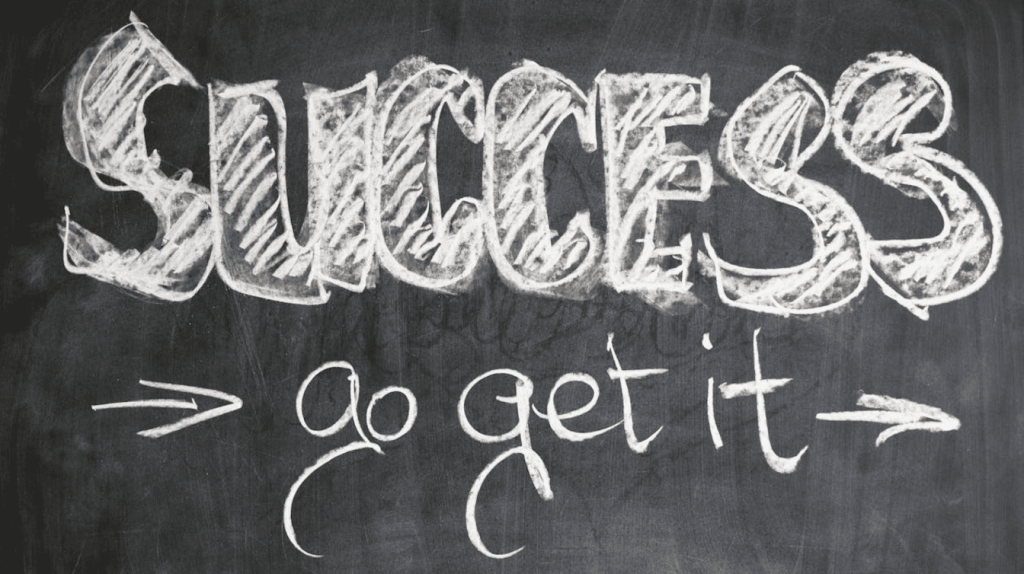 The phrase "Success go get it" written on a blackboard.