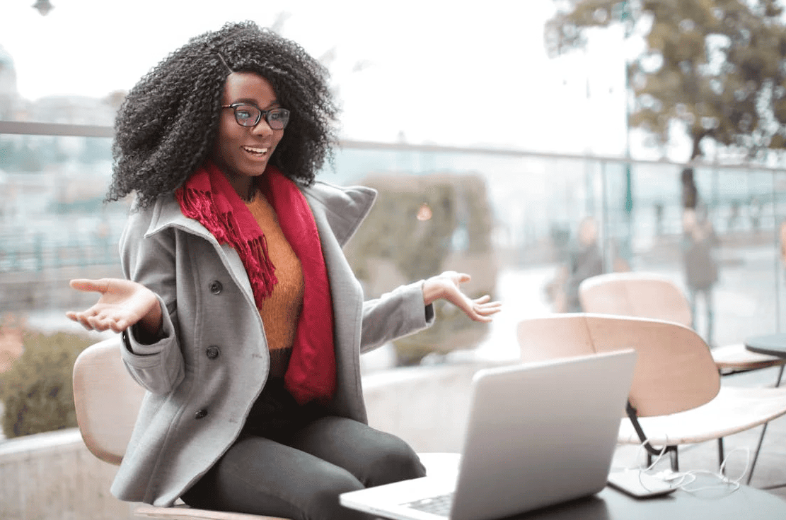 A woman with a happy expression in front of a laptop. 